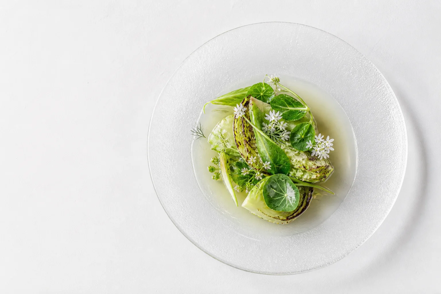 A botanical tasting dish served in a clear glass bowl